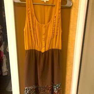 Sleeveless mustard and brown silky dress.